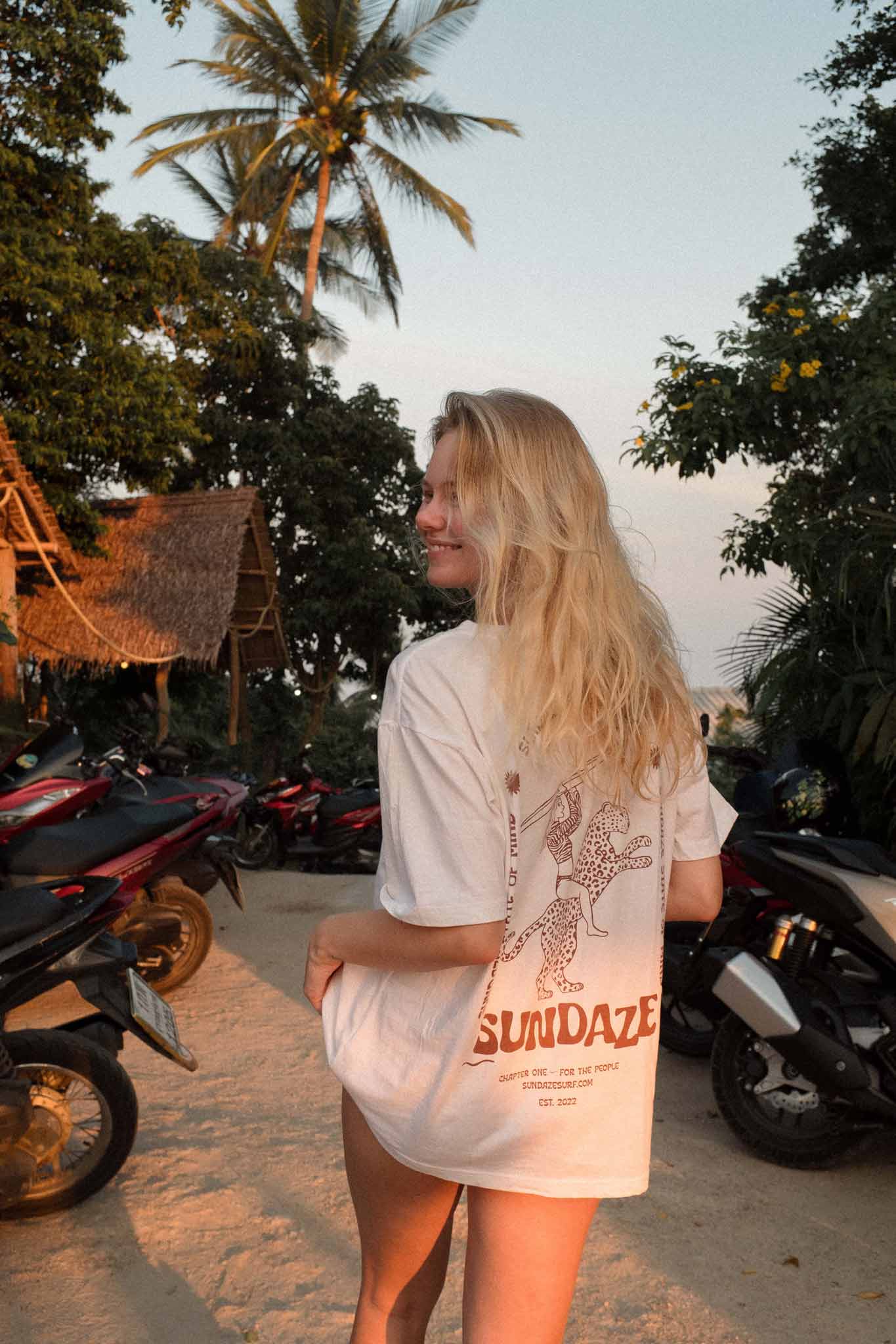 Model wearing the Chapter One Tee in tropical setting