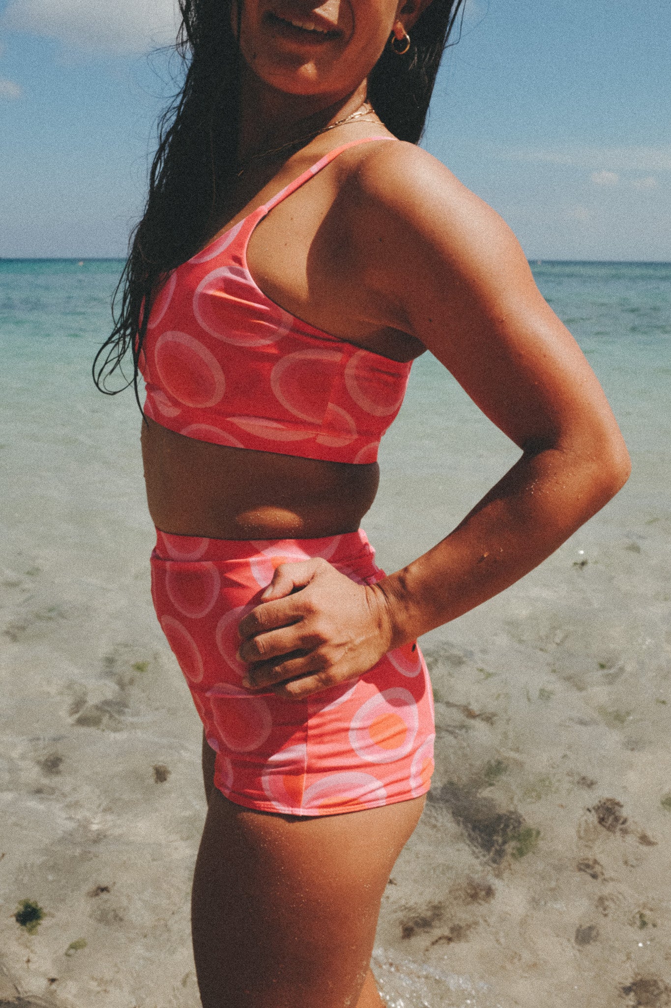 model posing at the beach wearing the watermelon bikini