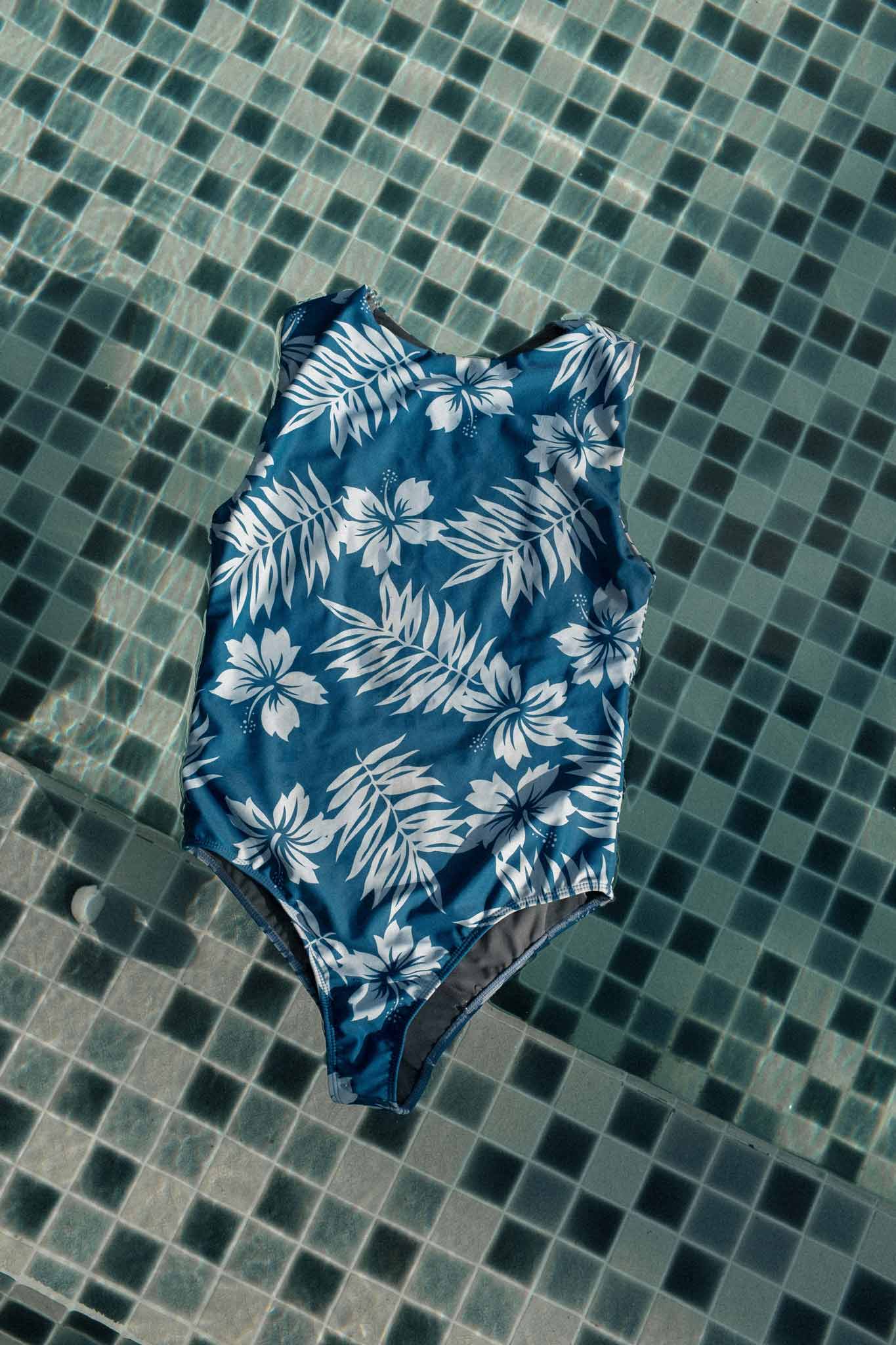 photo of the ketut surf suit in blue hibiscus in a swimming pool