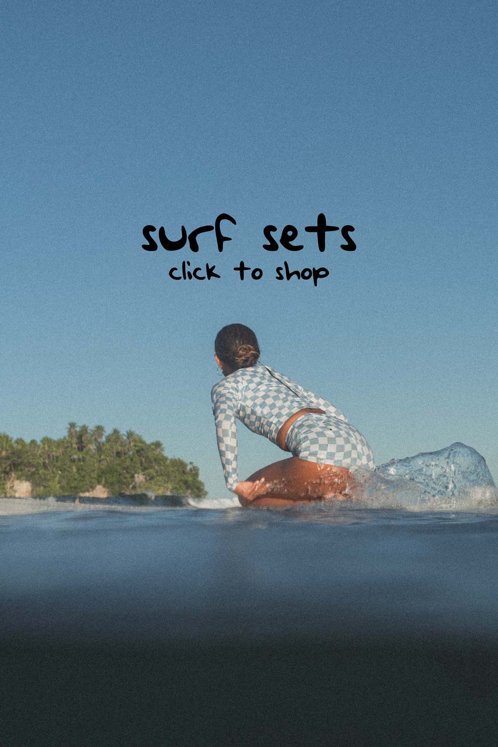 woman on a surfboard paddling and wearing a surf set with blue check print