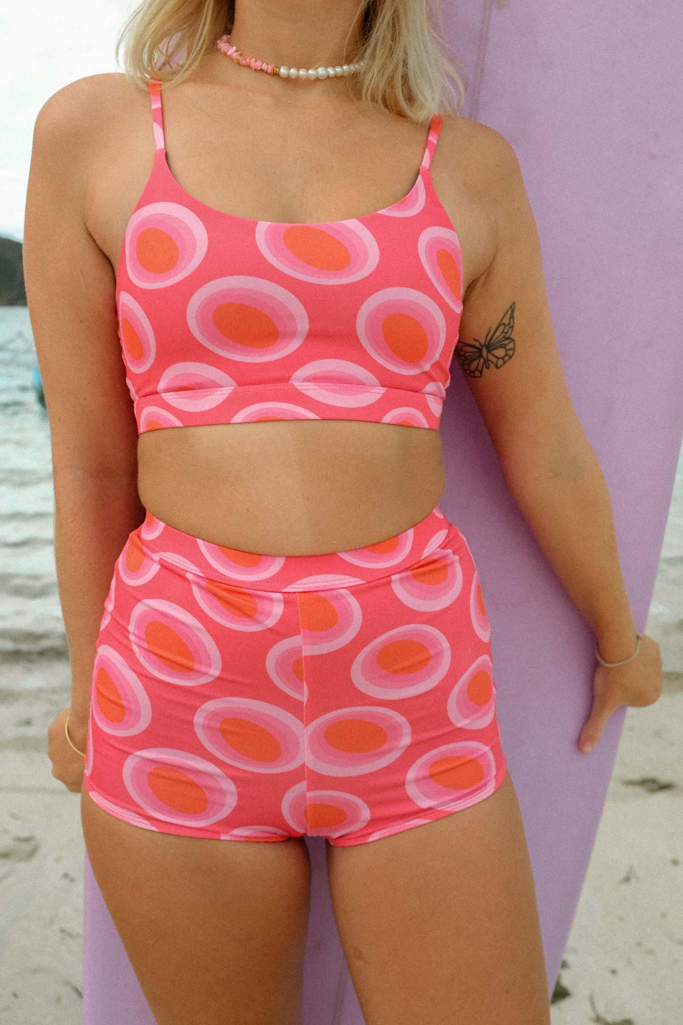 surfer posing at the beach wearing the surf bikini with watermelon print