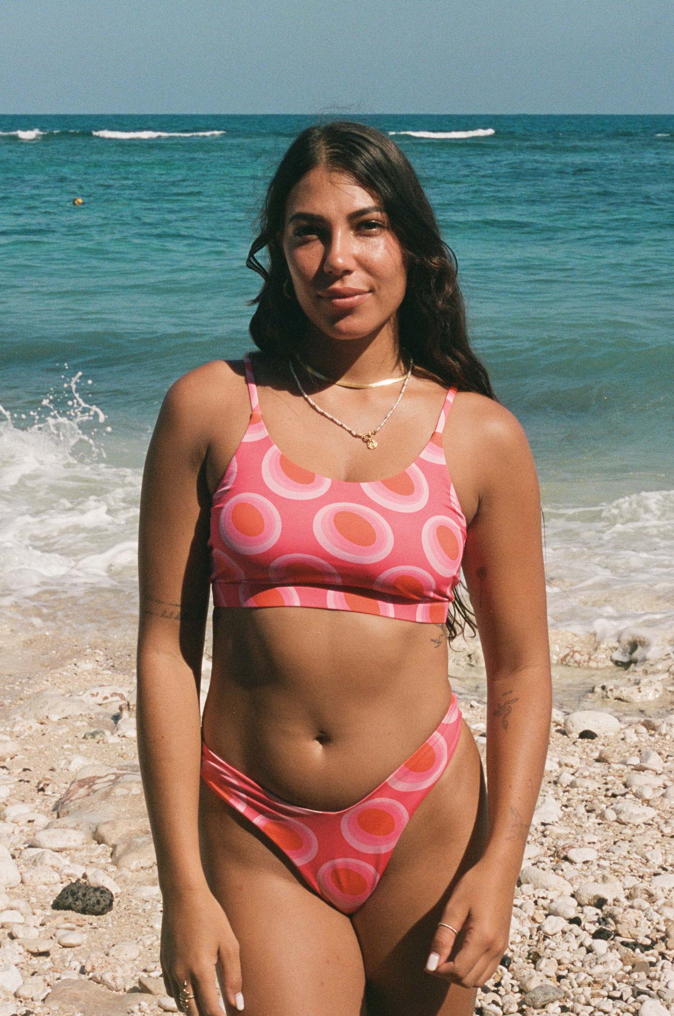 analogue photo of a model posing at the beach wearing the watermelon bikini
