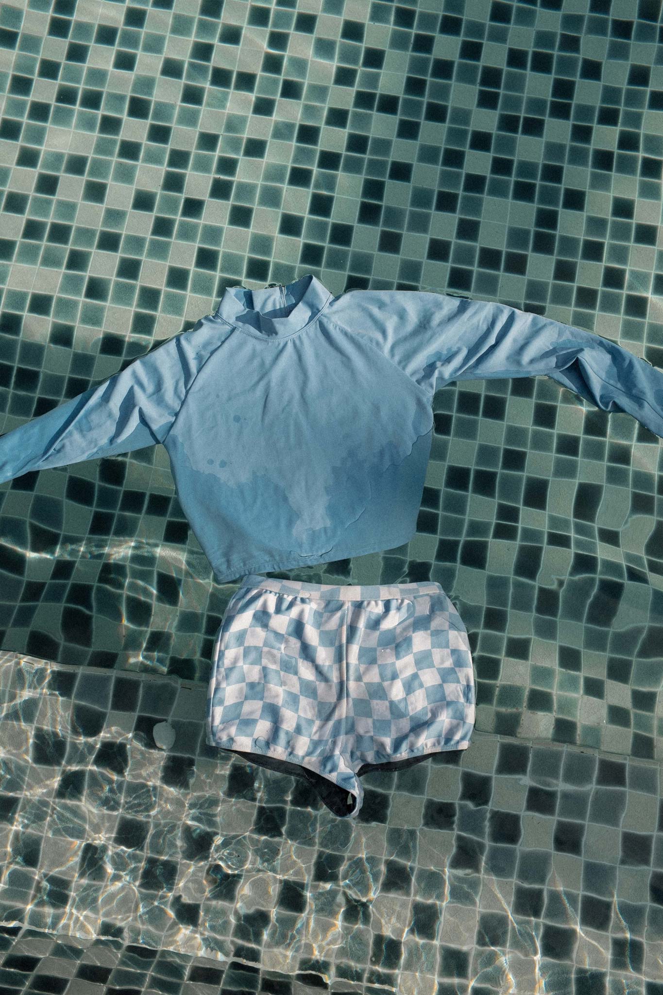 flatlay of the blue surf rash guard floating in a pool