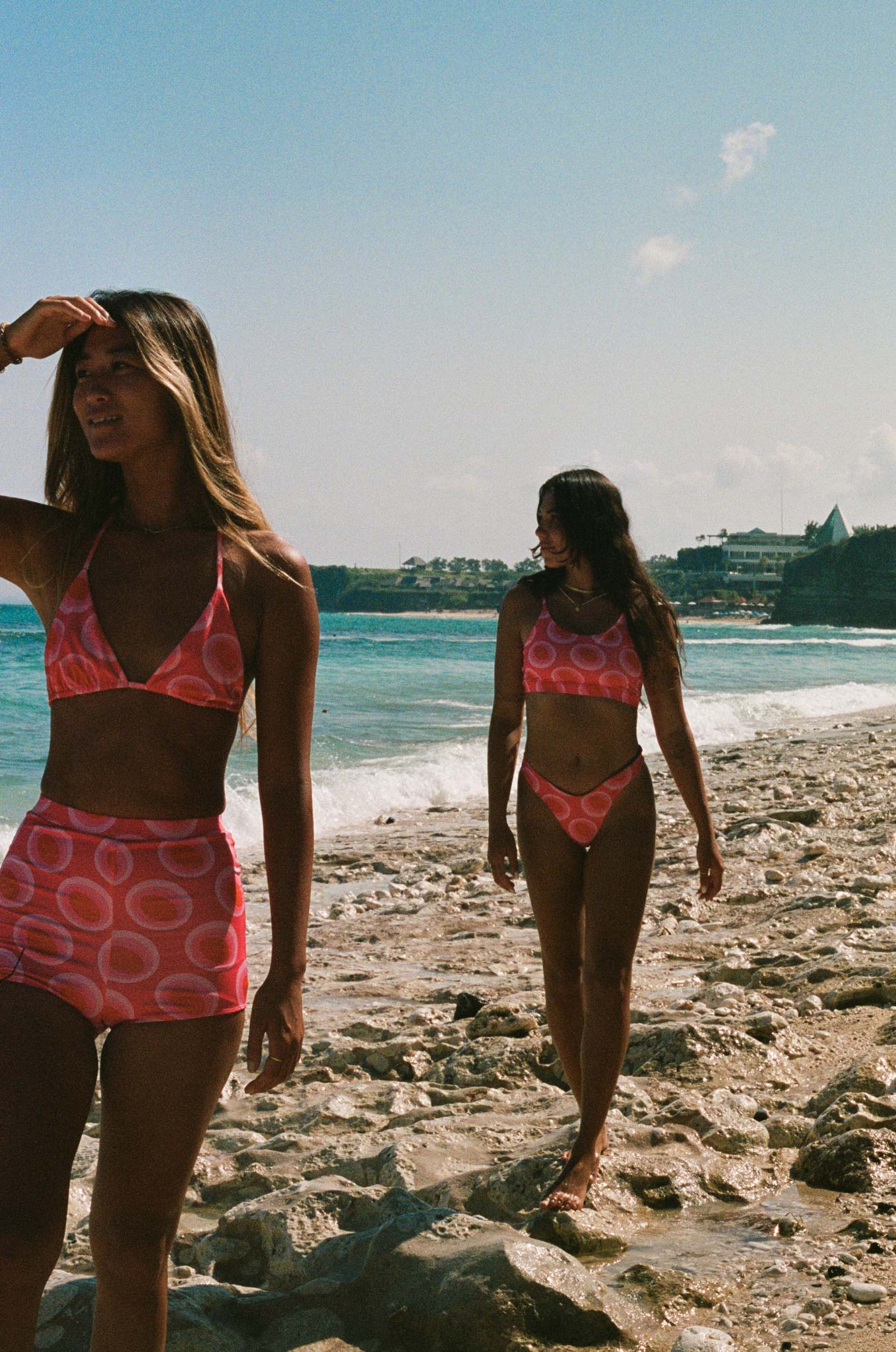 analogue photo of two models walking on the beach wearing the watermelon print
