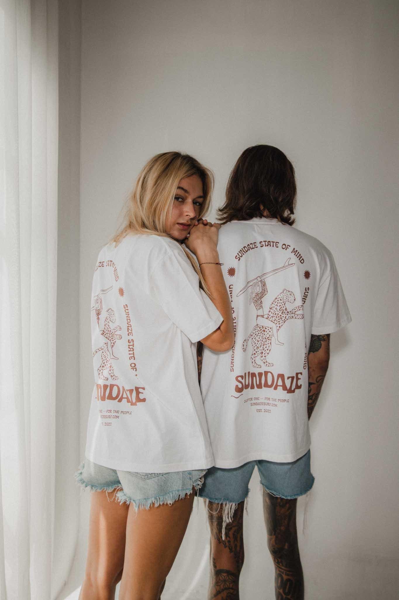 Two individuals in Chapter One Organic Cotton T-Shirts with 'SunDaze' print